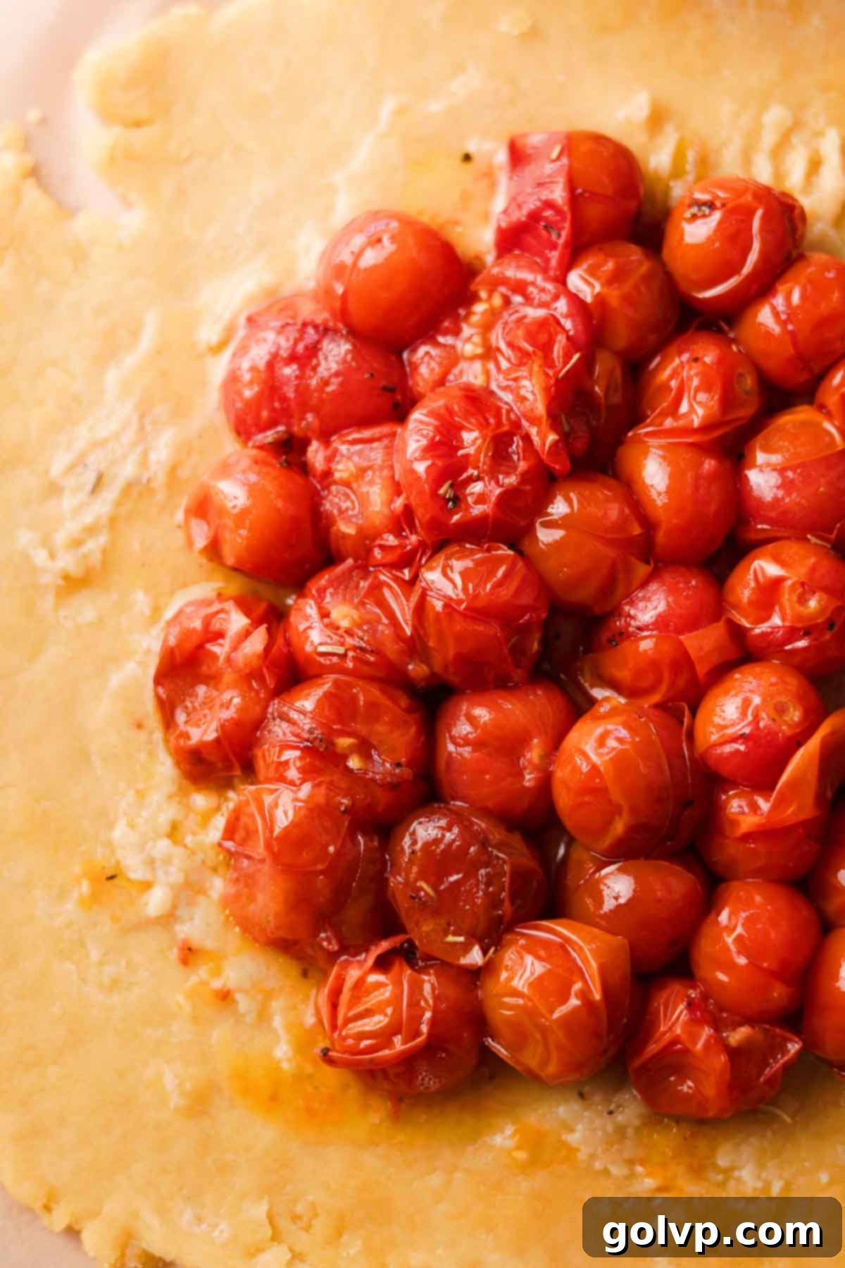 Carefully topping the galette pastry with whole confit cherry tomatoes