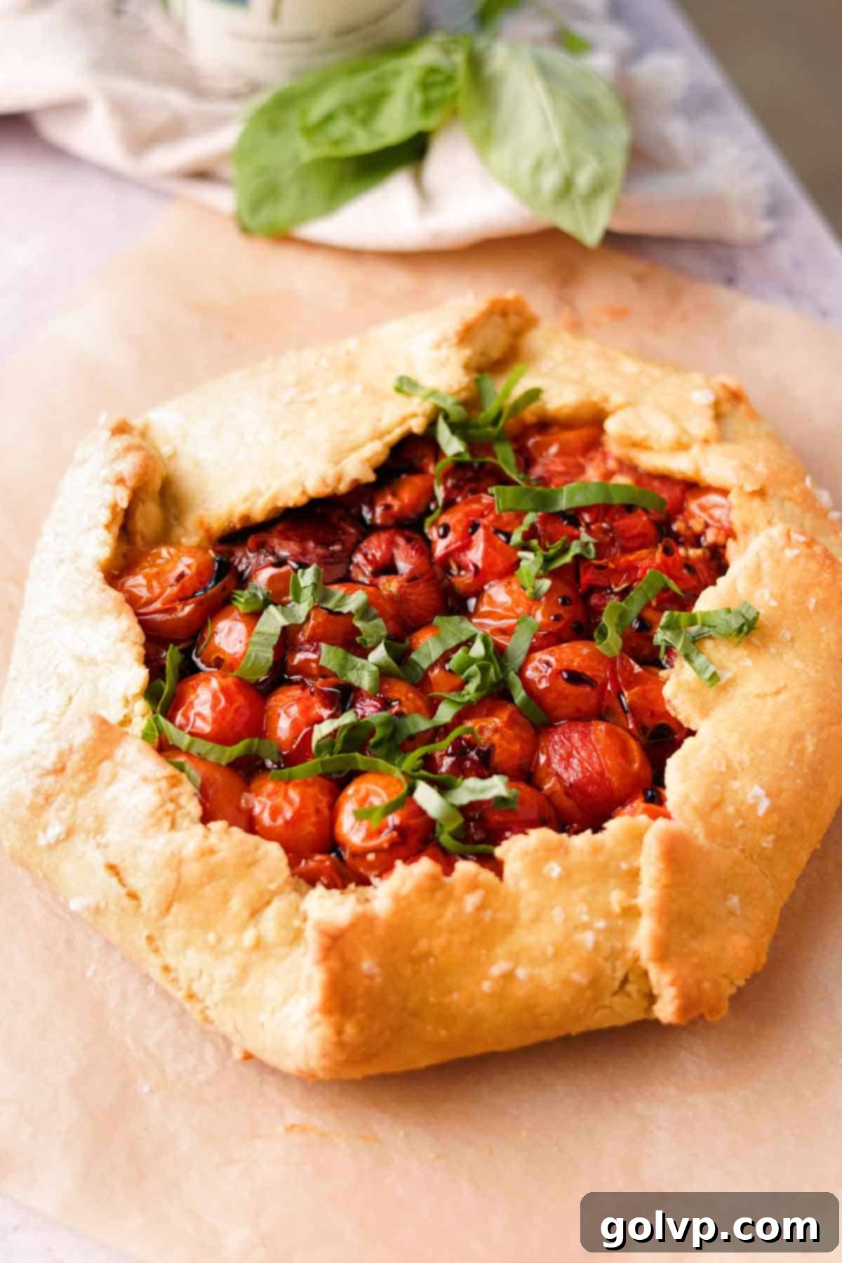 Freshly baked tomato galette drizzled with balsamic glaze and sprinkled with basil