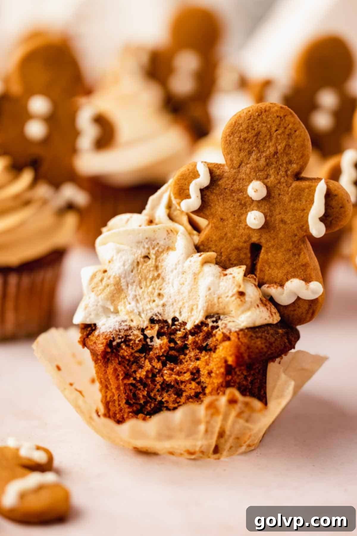 bitten gingerbread cupcake with frosting and mini frosted gingerbread man cookie