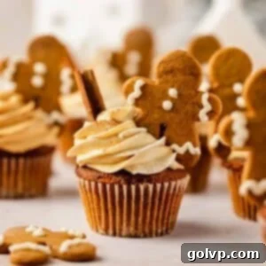 gingerbread cupcakes with gingerbread frosting and mini gingerbread men with evergreen tree in the back