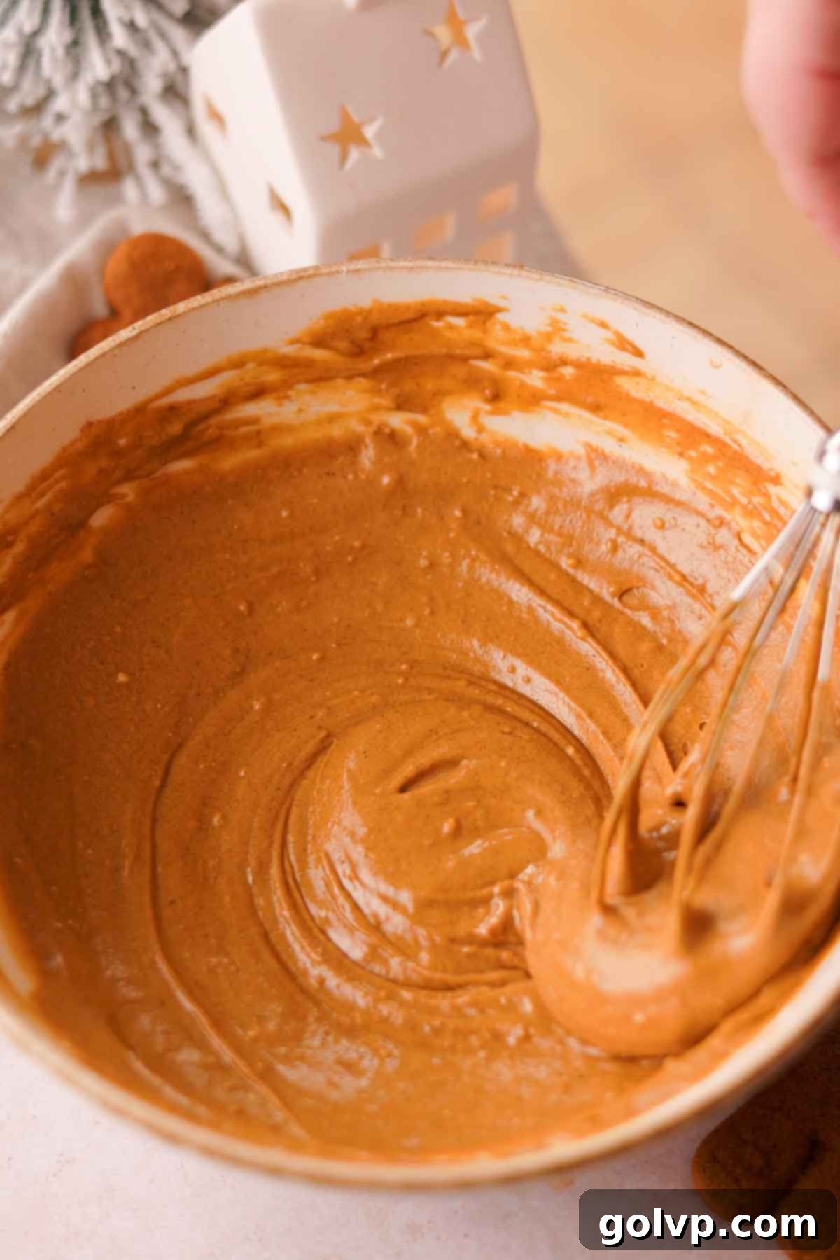 folding gingerbread batter with a handheld wire whisk