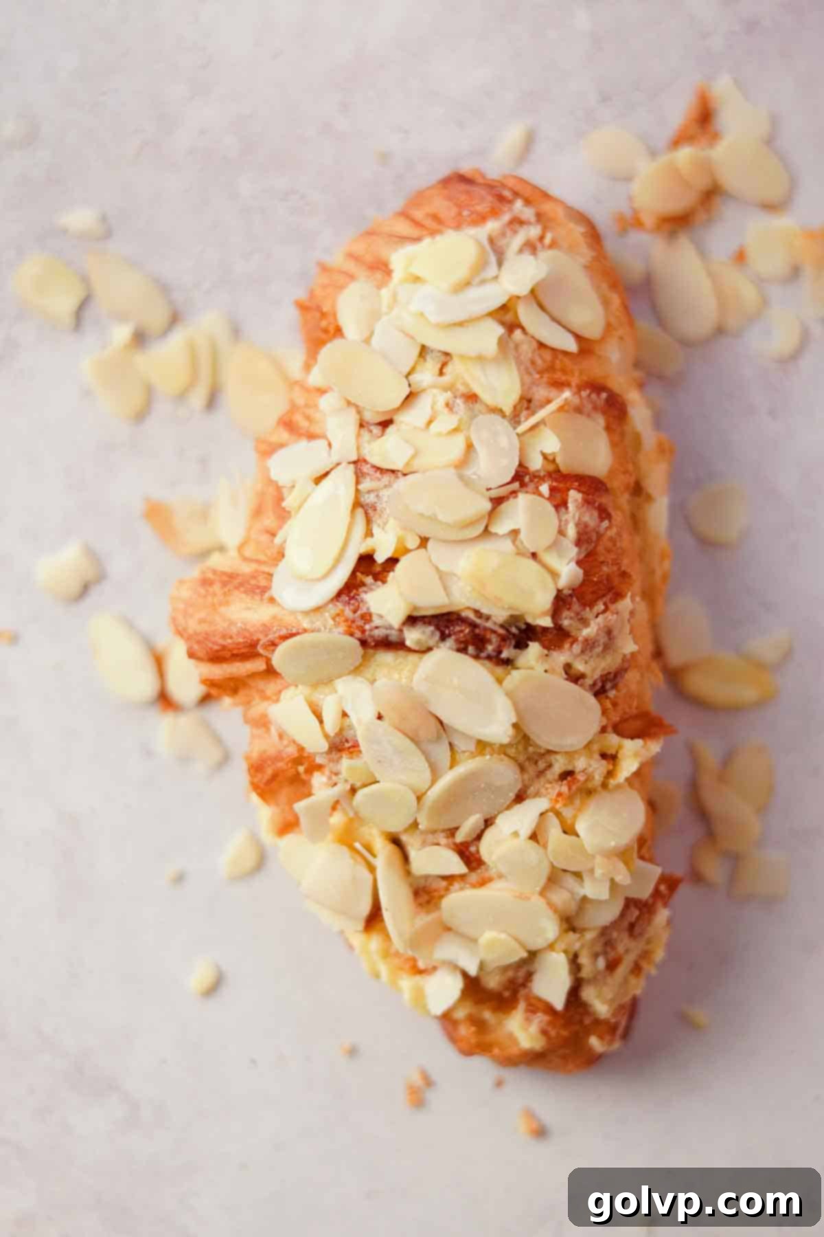 topping almond croissant with sliced almonds