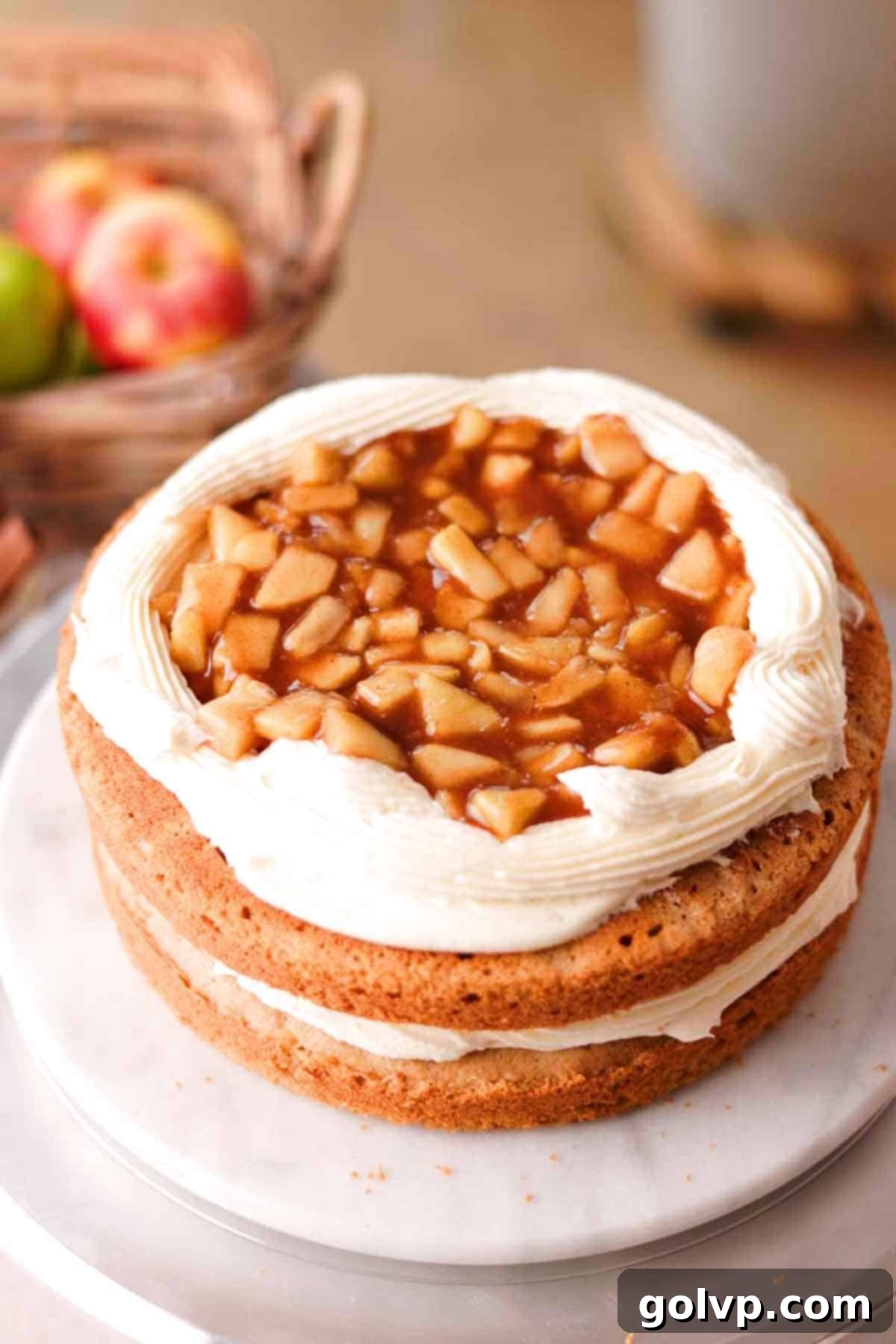 stacked cake layers with border of frosting and apple filling inside