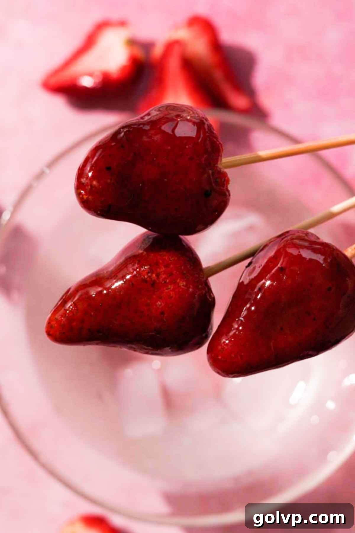 Rows of shiny, dark chocolate strawberry Tanghulu on skewers, glistening with a hardened candy coating