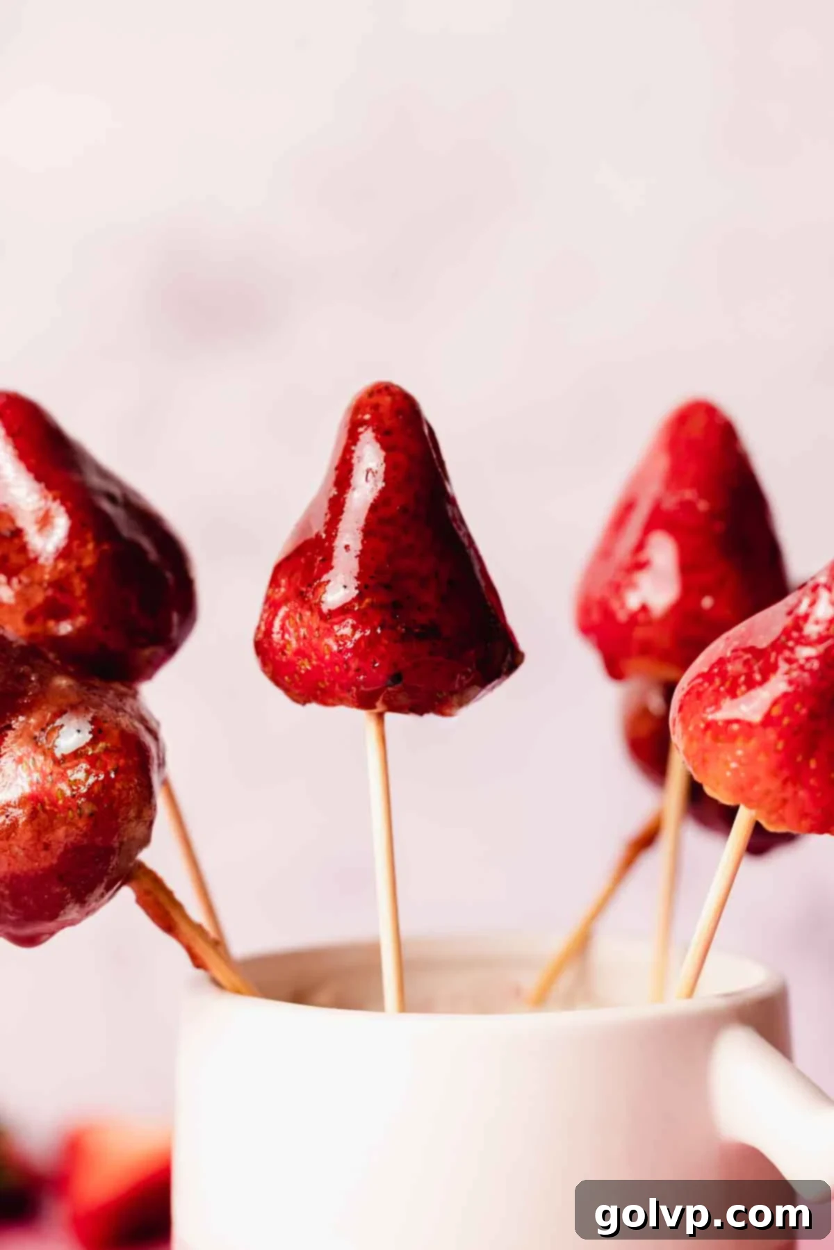 A glistening chocolate strawberry Tanghulu on a skewer, showcasing its dark, smooth candy shell