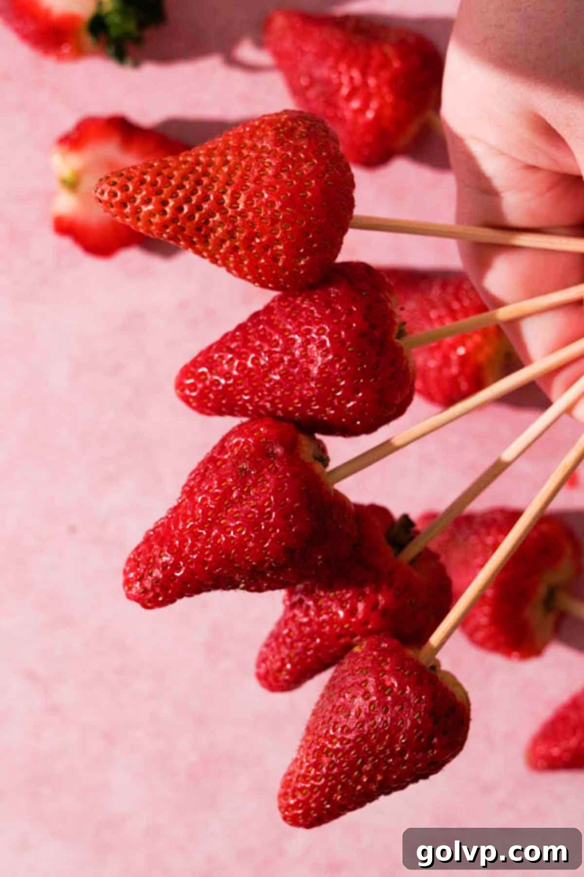 Fresh, dry strawberries on bamboo skewers, ready for coating