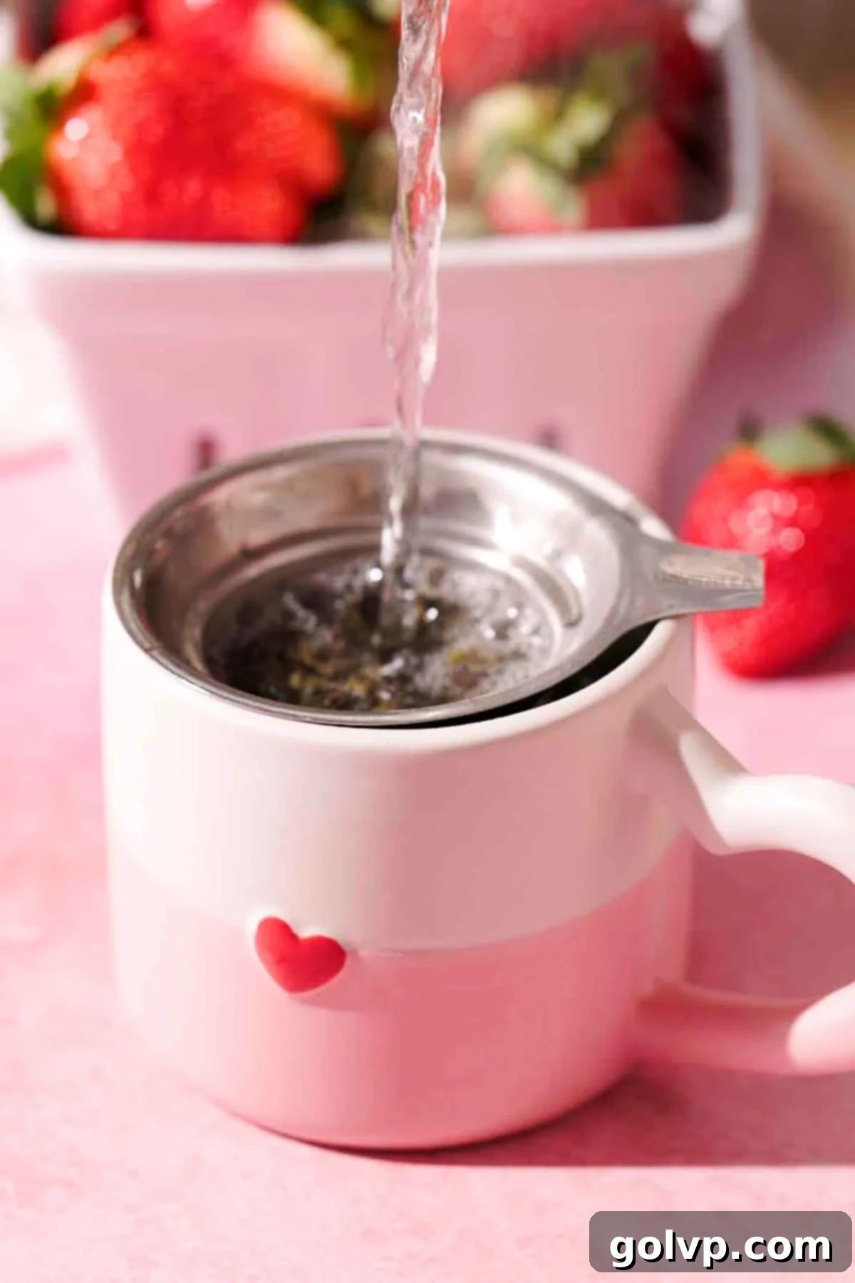 steeping strong green tea in pink cup with red heart