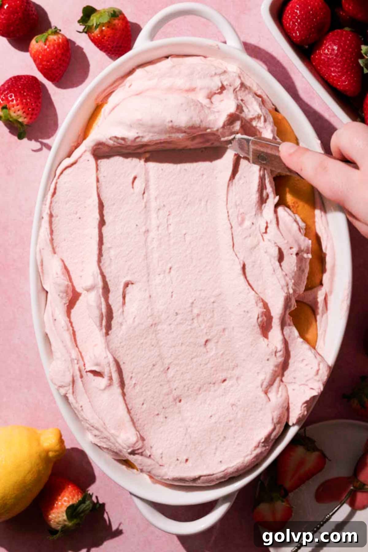 smoothing strawberry mascarpone filling on top of ladyfingers