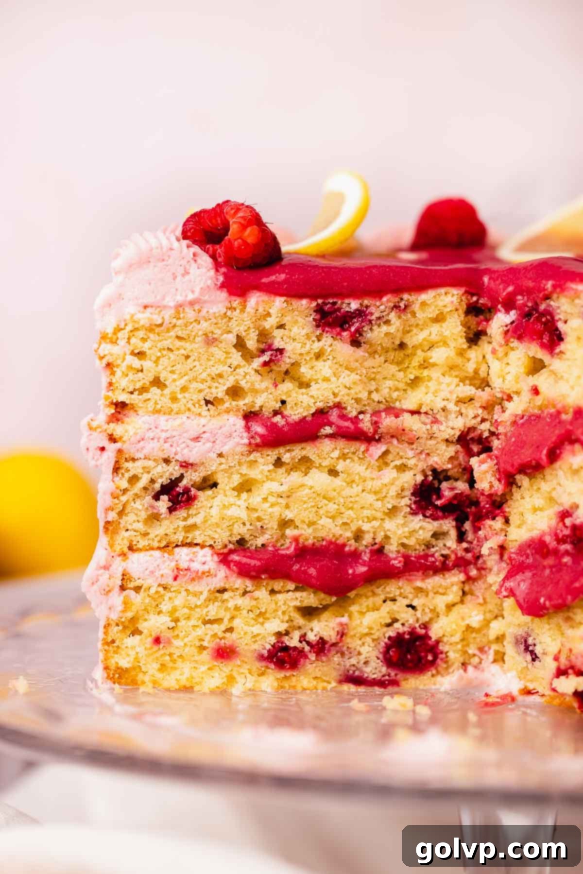 cross section of lemon raspberry layer cake with gooey raspberry curd filling 