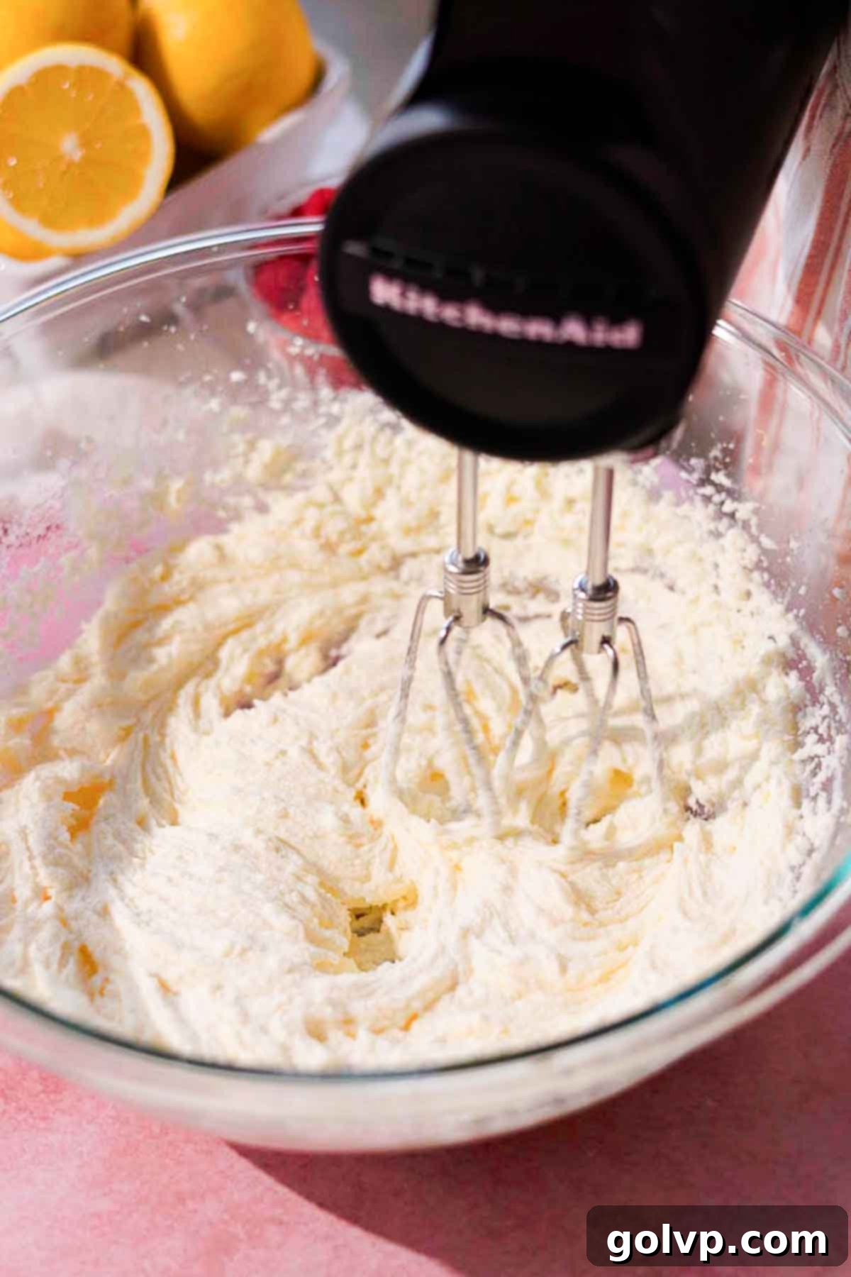 beating butter, sugar, and oil in large glass bowl with electric hand held mixer 