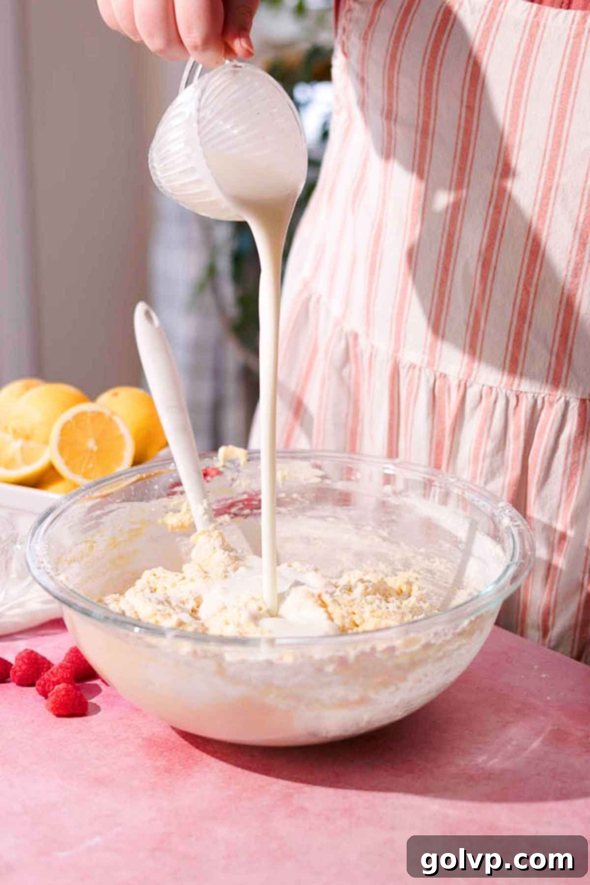 pouring buttermilk into large bowl full of cake batter