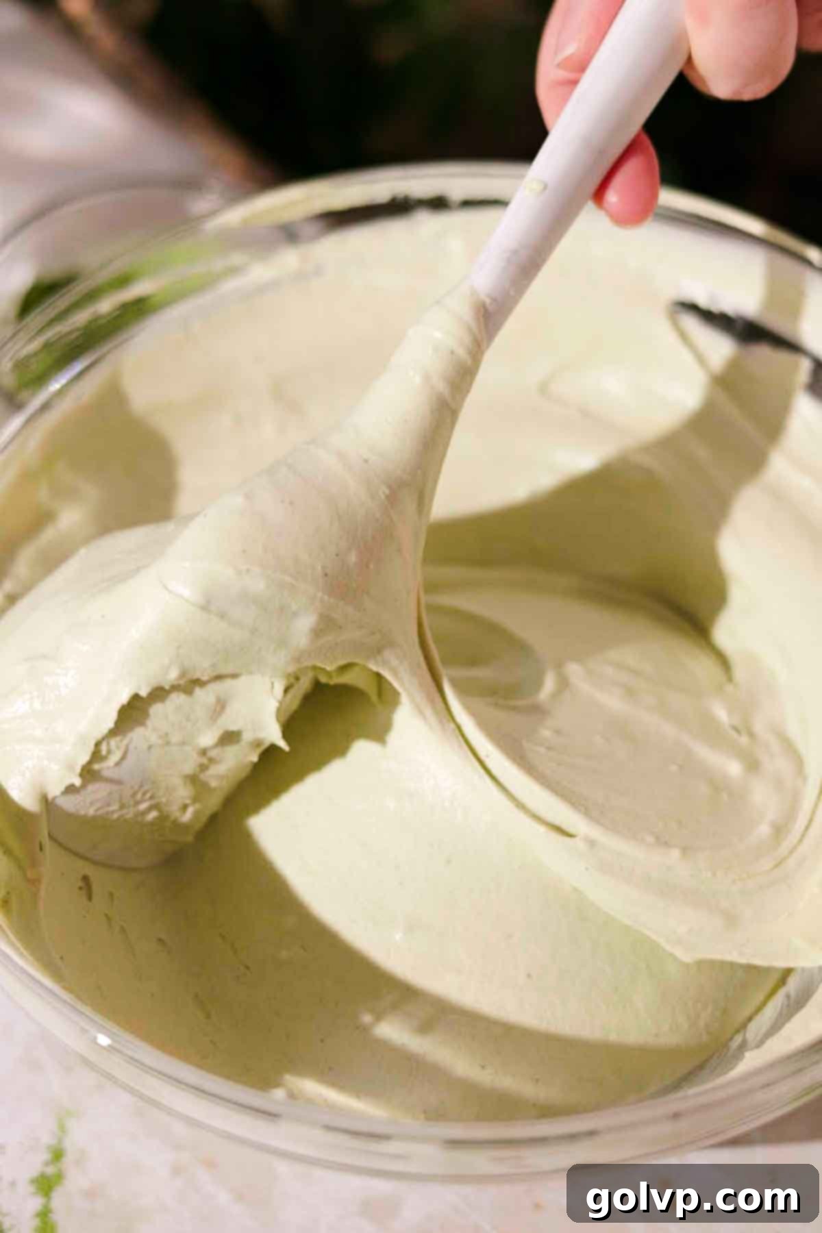 gently folding the whipped cream into the matcha mascarpone mixture