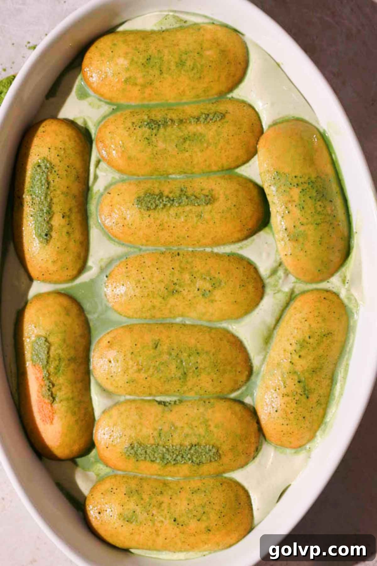 a layer of matcha soaked ladyfingers placed on top of creamy matcha filling