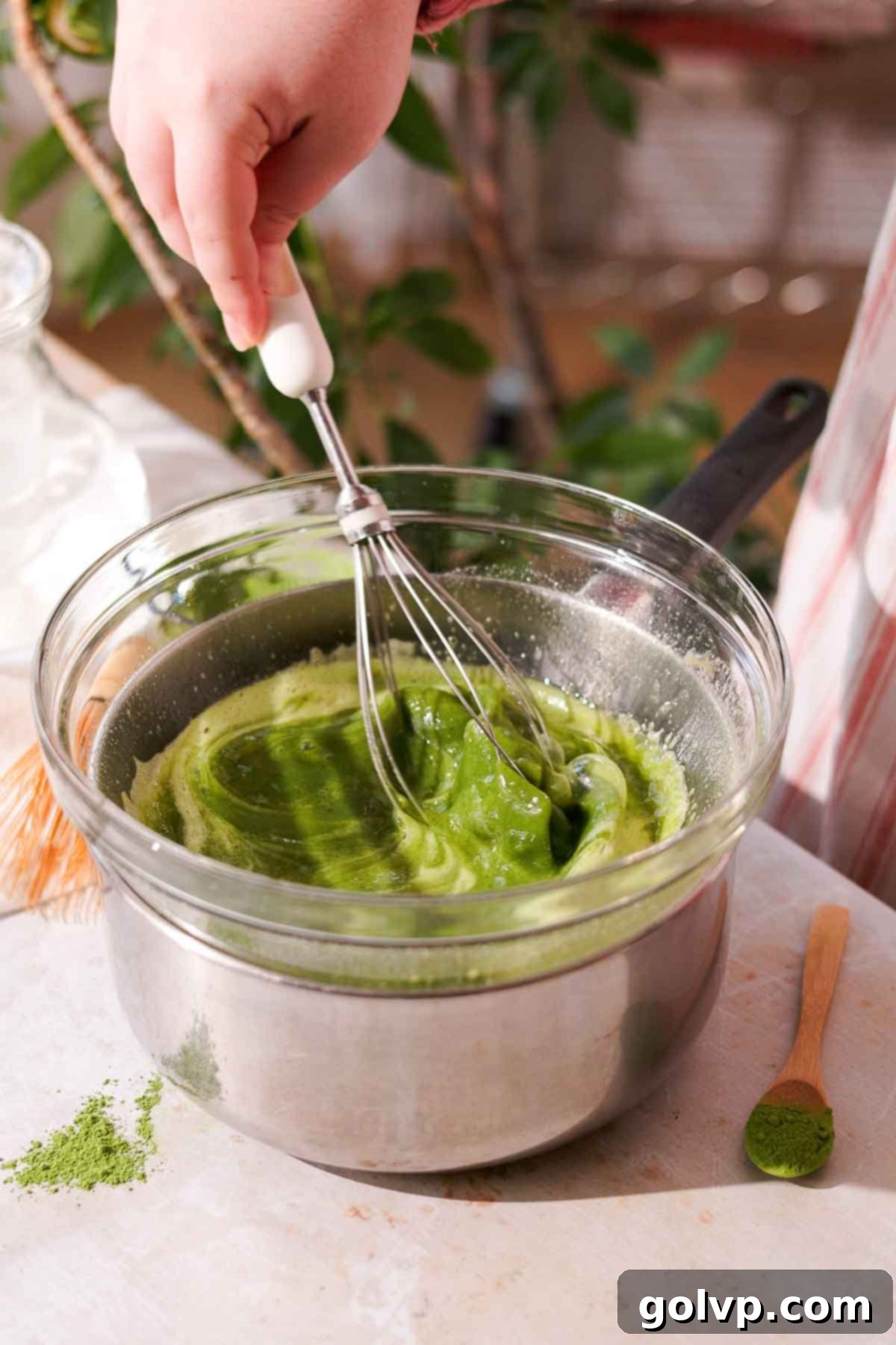 whisking matcha custard filling over a double boiler until thickened and foamy