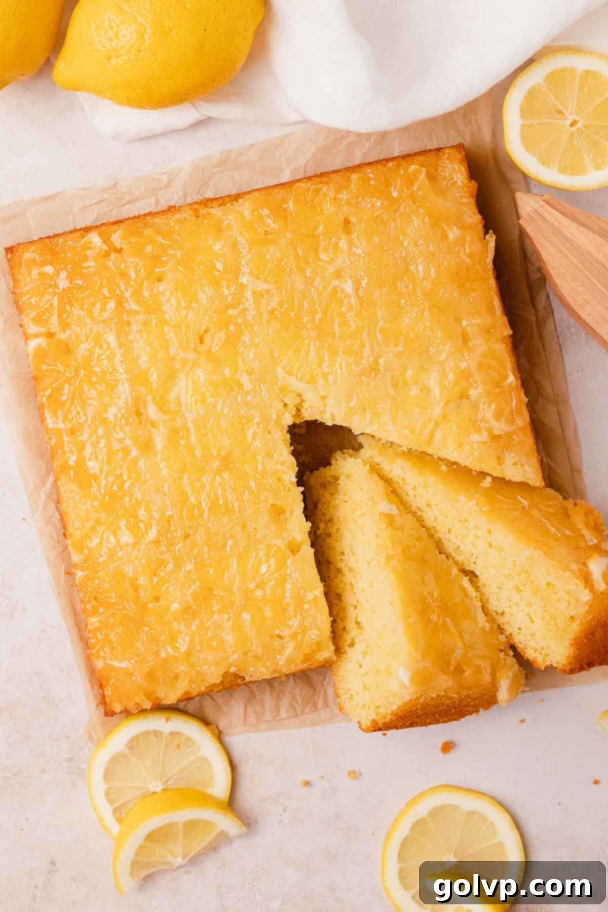 Two slices of a golden-brown lemon olive oil upside down cake with a glossy, sticky lemon topping, ready to be served.