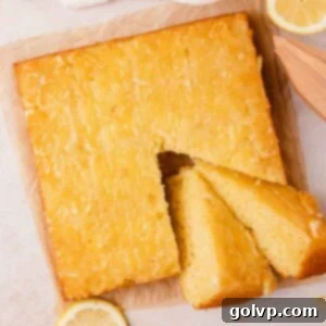 Lemon olive oil upside down cake cut into two slices, showcasing the sticky lemon topping and moist interior.