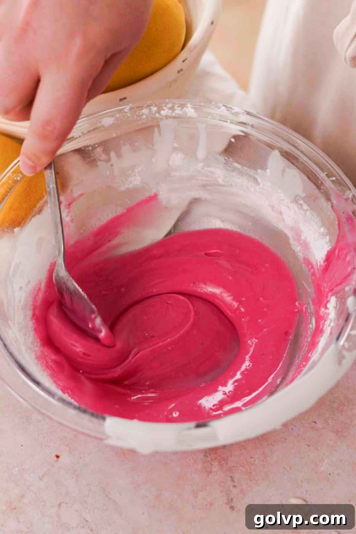 Making the purple blueberry glaze by mixing powdered sugar with liquid extracted from thawed blueberries