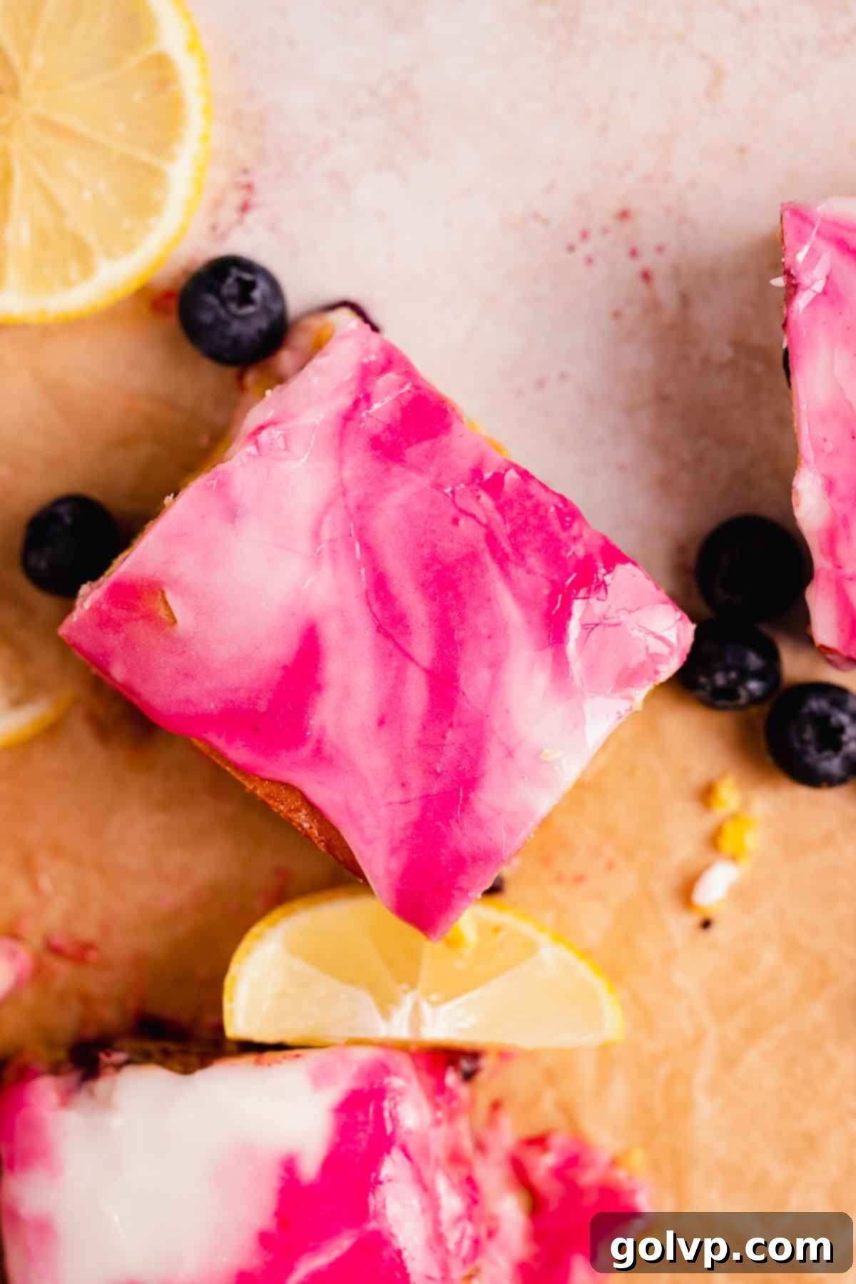Close-up of a single blueberry lemon brownie with swirled purple and white glaze, highlighting the fudgy texture and juicy blueberries inside