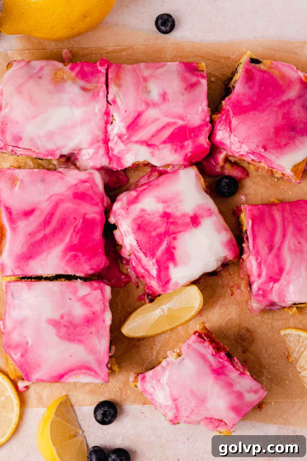 Glazed blueberry lemon brownies with a beautiful swirled white and purple glaze, showing off the individual squares ready to be served
