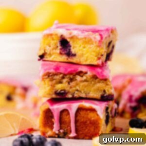 Stack of fudgy blueberry lemon brownies with a vibrant lemon and swirled blueberry glaze, ready to be enjoyed
