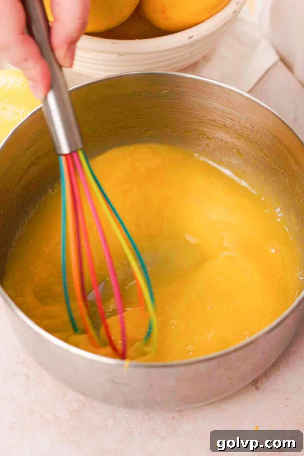 whisking lemon curd ingredients in a saucepan
