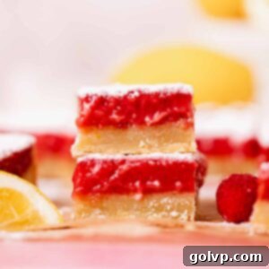 Stacked lemon raspberry bars with a golden shortbread crust and a thick, gooey, vibrant red lemon raspberry filling.