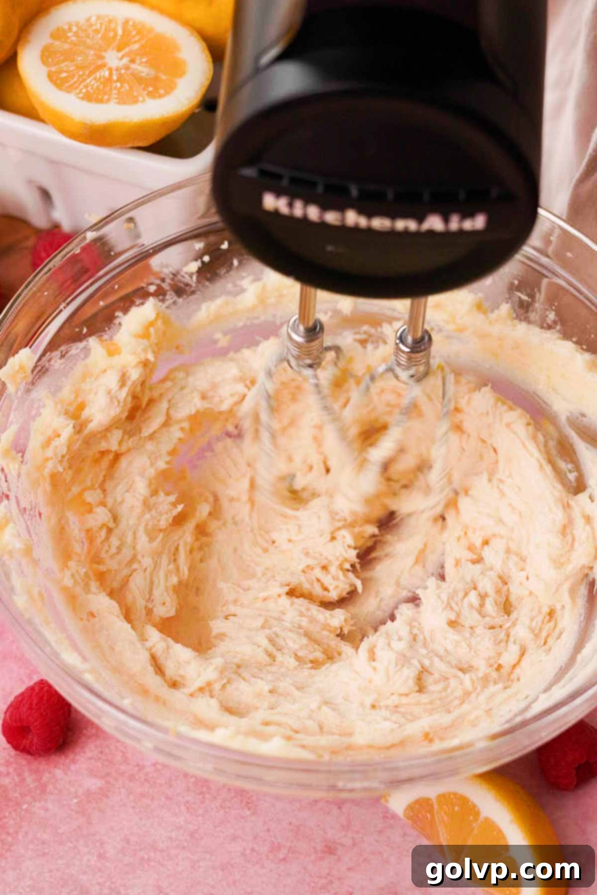Beating softened butter, lemon-infused sugar, and vanilla extract together in a mixer until fluffy and lightened for the shortbread crust.