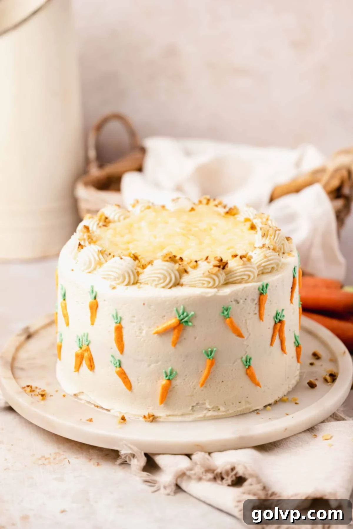 carrot cake with pineapple on cake stand with mini piped carrots on sides