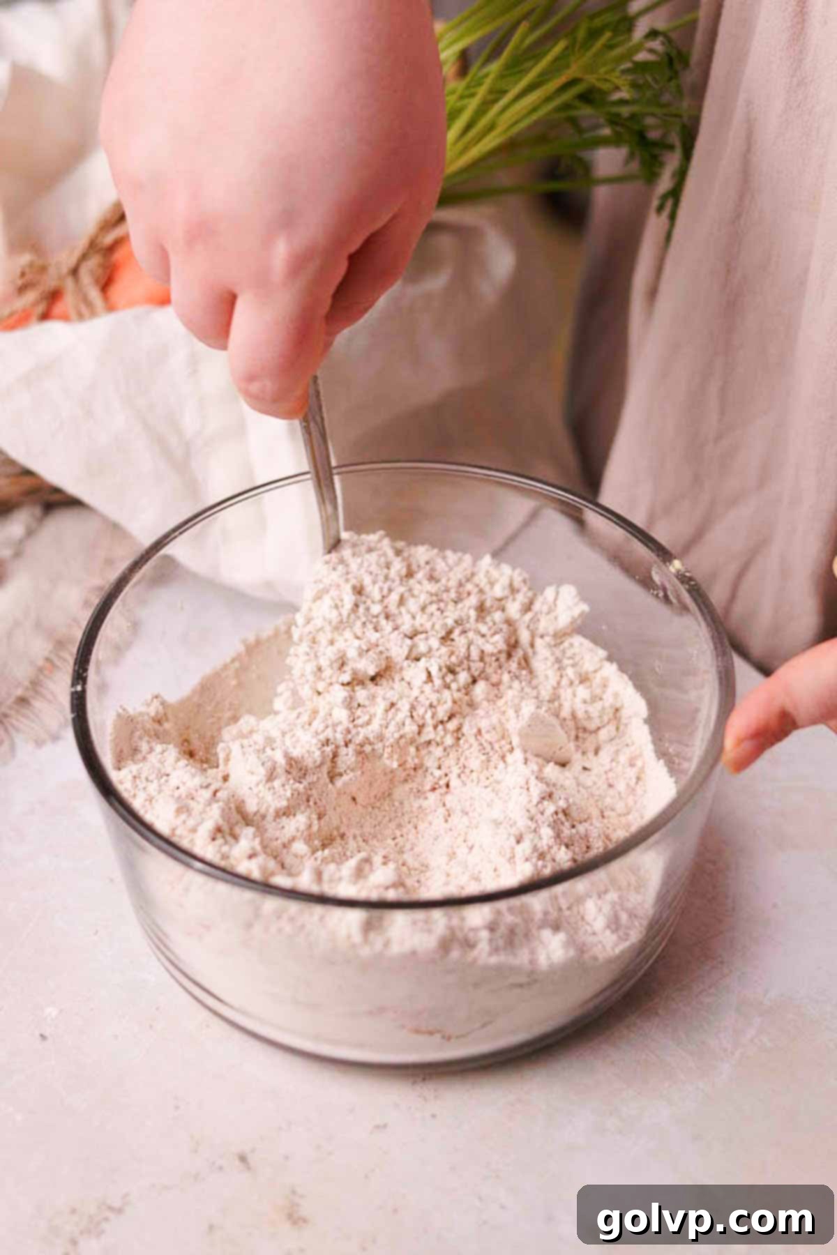 combining dry ingredients in a glass container with a spoon