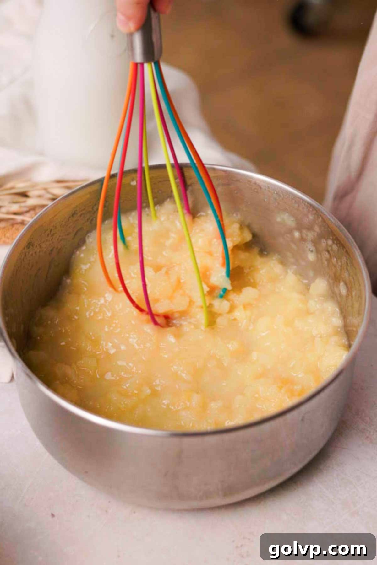 whisking pineapple filling in a saucepan with a whisk