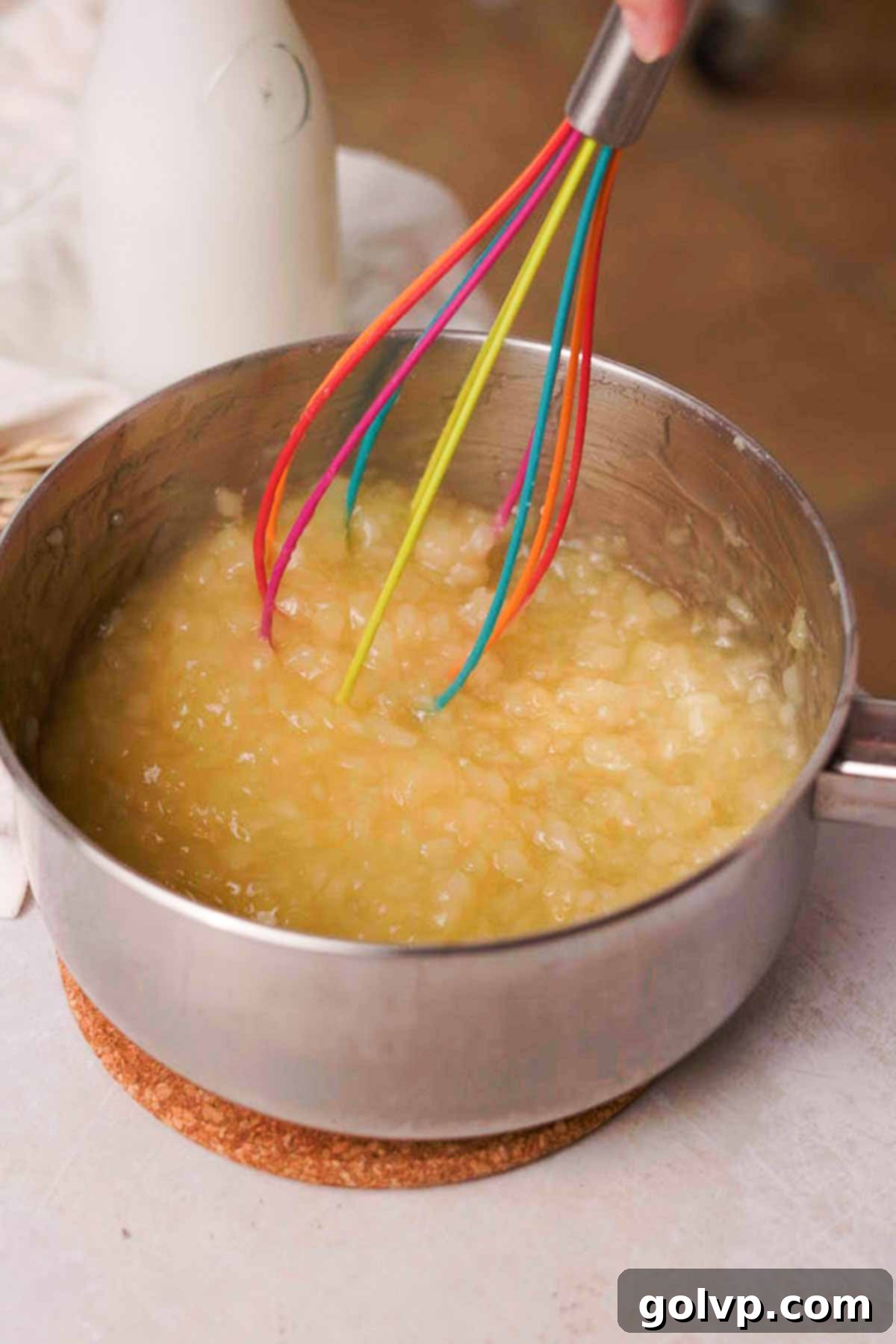 stirring cooked pineapple filling with a whisk