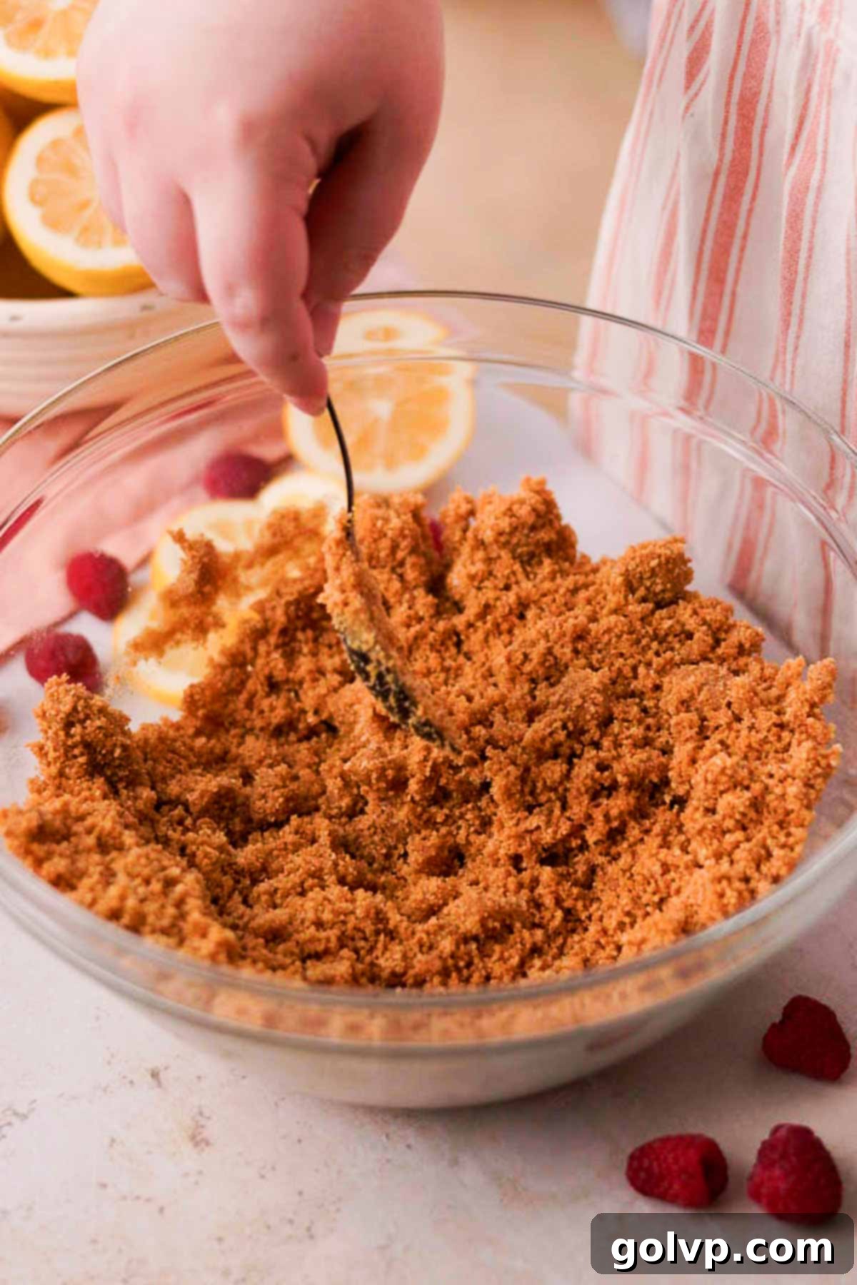 stirring graham cracker crust ingredients together in glass bowl with a spoon