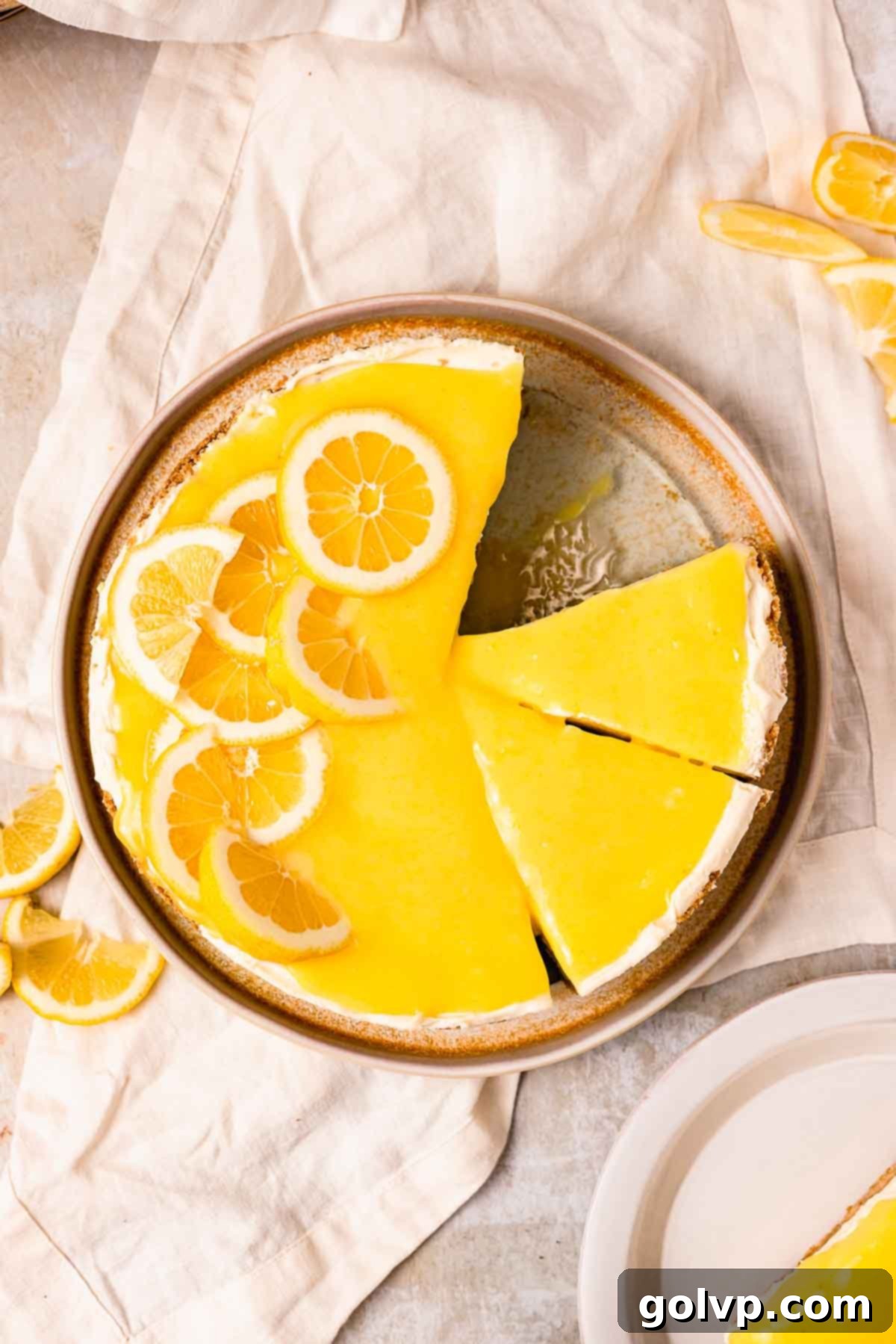 lemon curd cheesecake flatlay with lemon curd and sliced lemons on top