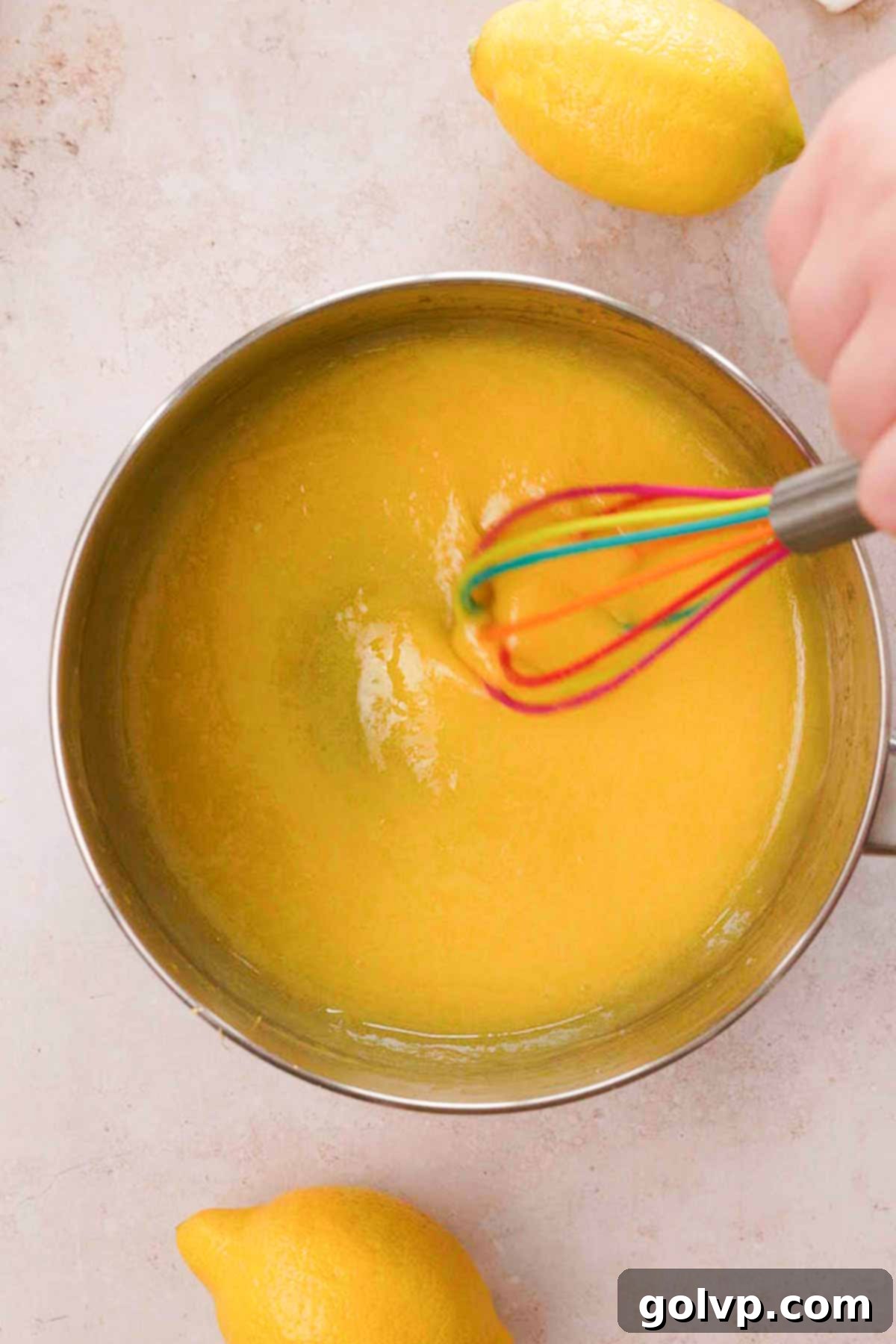 whisking cooked lemon curd in saucepan
