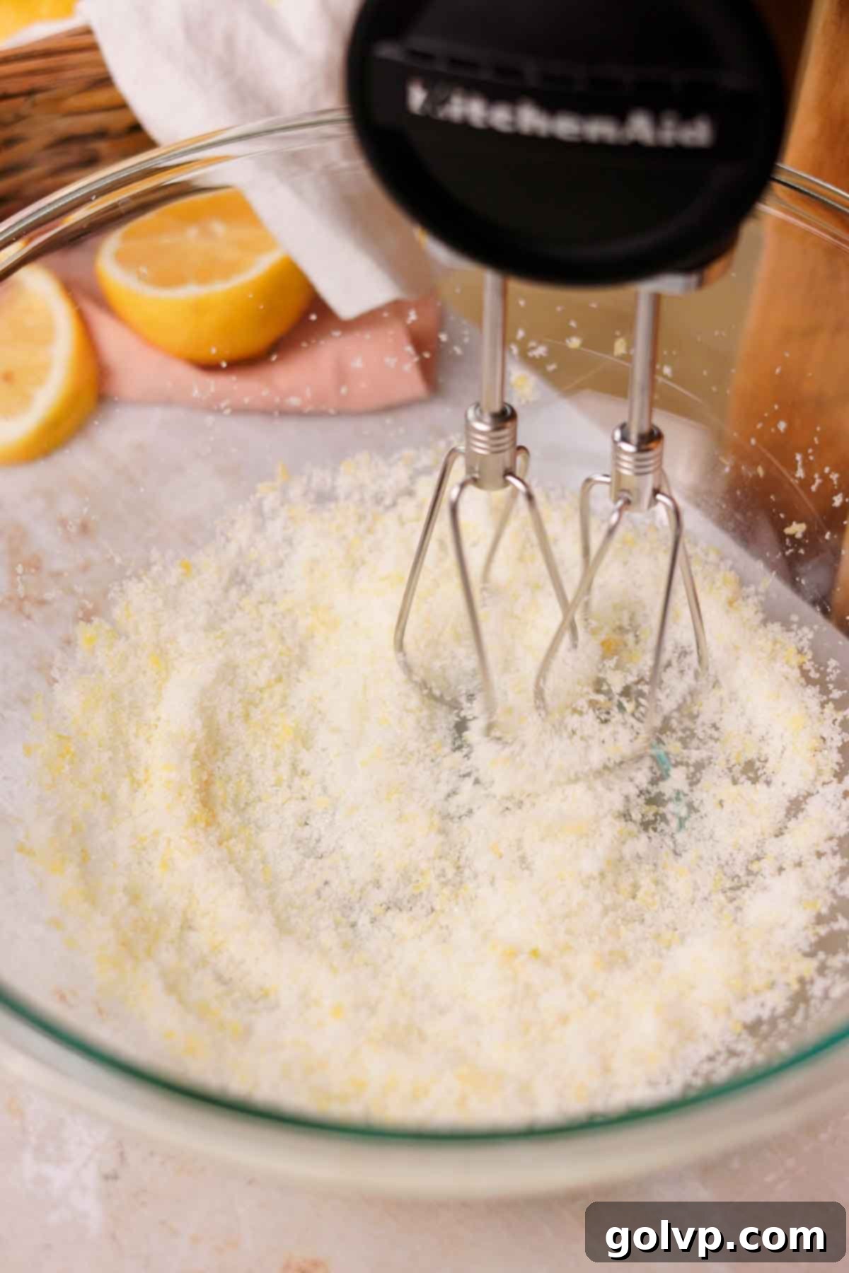rubbing lemon zest and sugar together with a handheld electric mixer