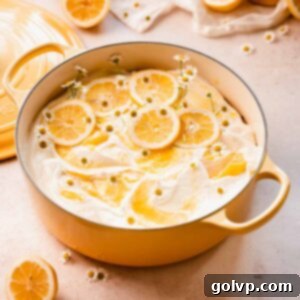 A stunning decorated lemon poke cake in a Dutch oven, ready to be served.