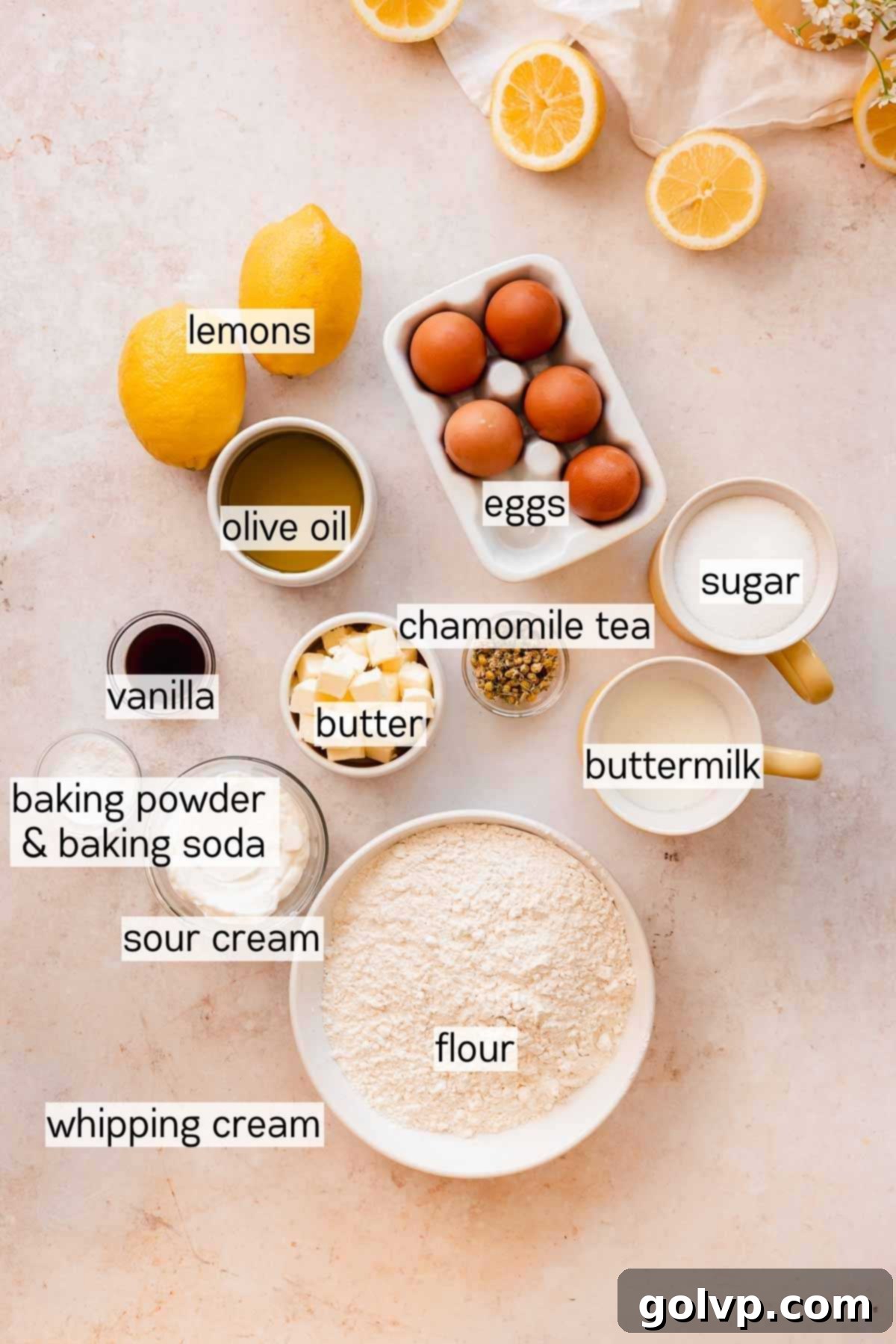 A collection of fresh lemon poke cake ingredients, including lemons, chamomile tea, eggs, and dairy, neatly arranged in small bowls on a wooden surface.
