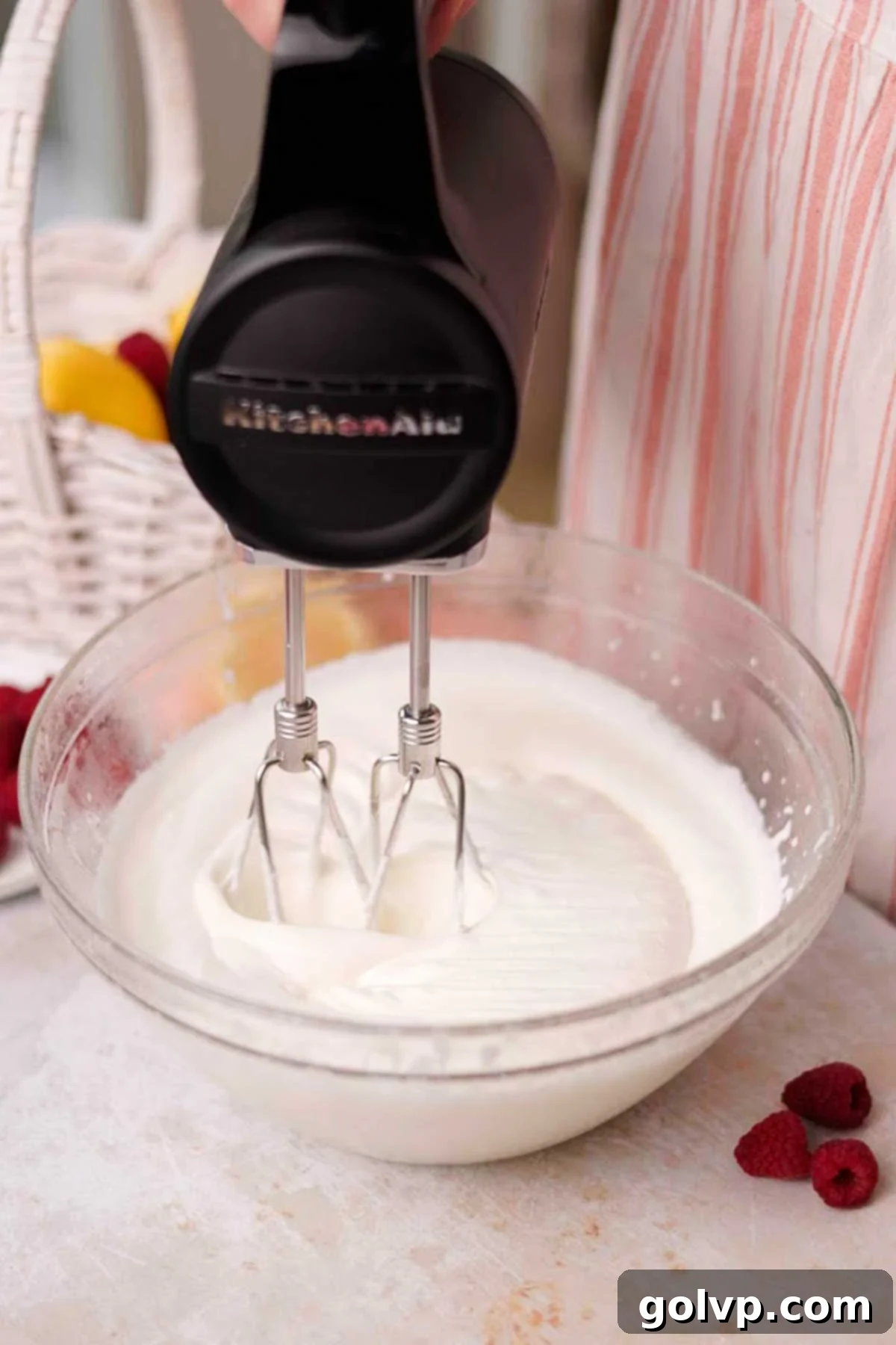 whipping cream for raspberry tiramisu in glass bowl