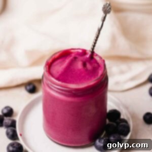 bright purple blueberry curd in jar with silver spoon
