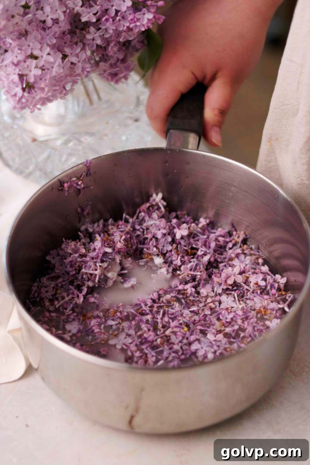uncooked lilac syrup in a metal saucepan