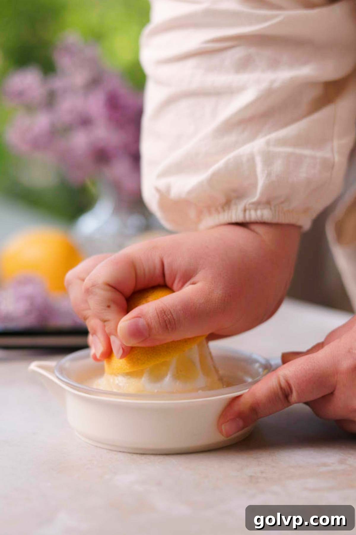squeezing lemon half with a lemon squeezer