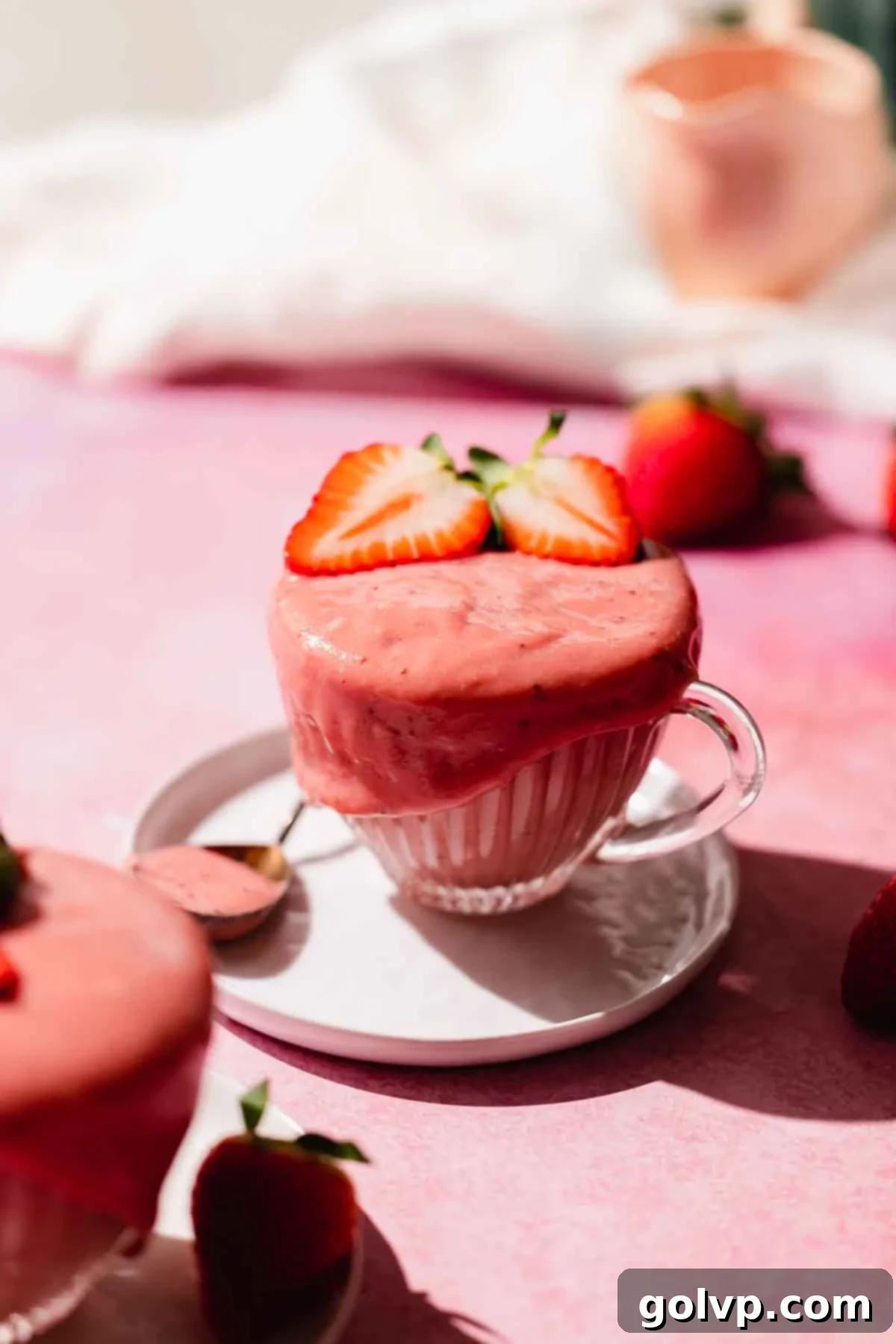 strawberry curd in a cup with fresh strawberries on top