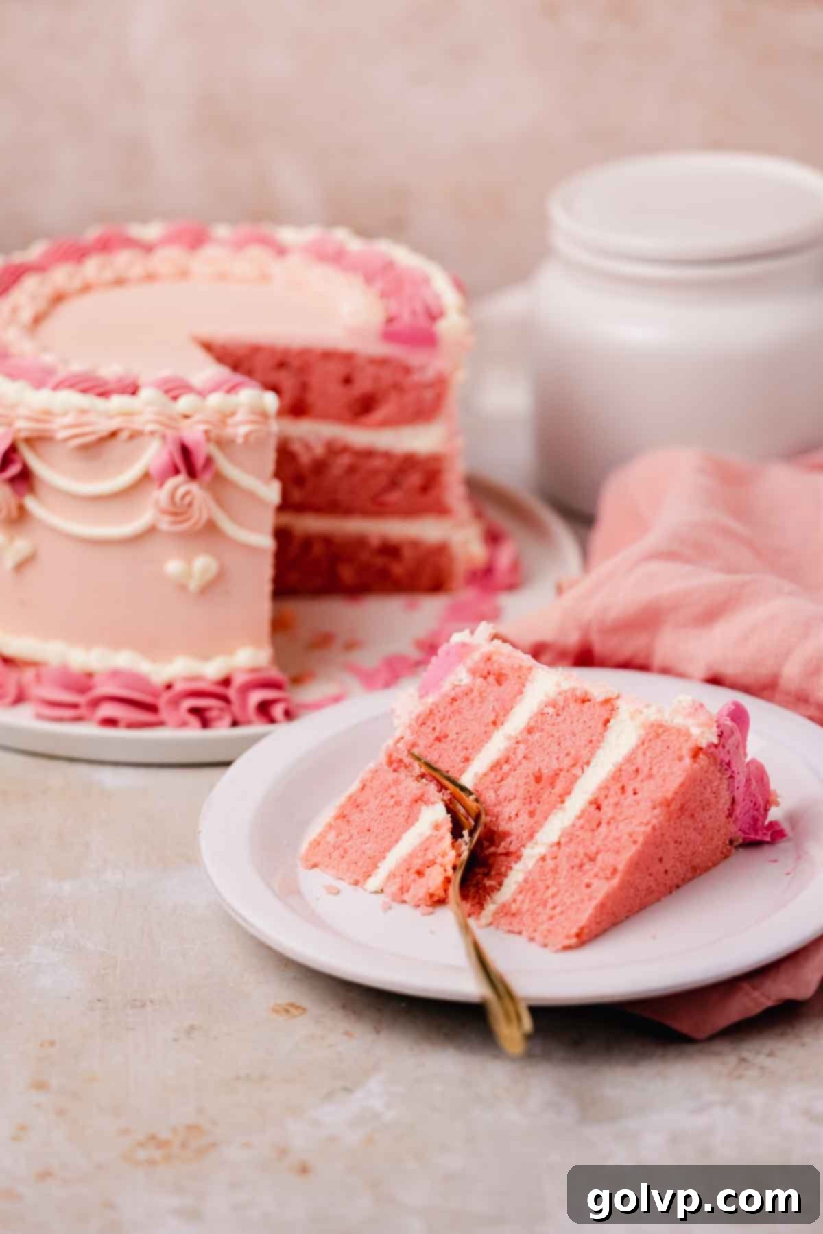 slice of pink velvet cake on a plate with a fork through it