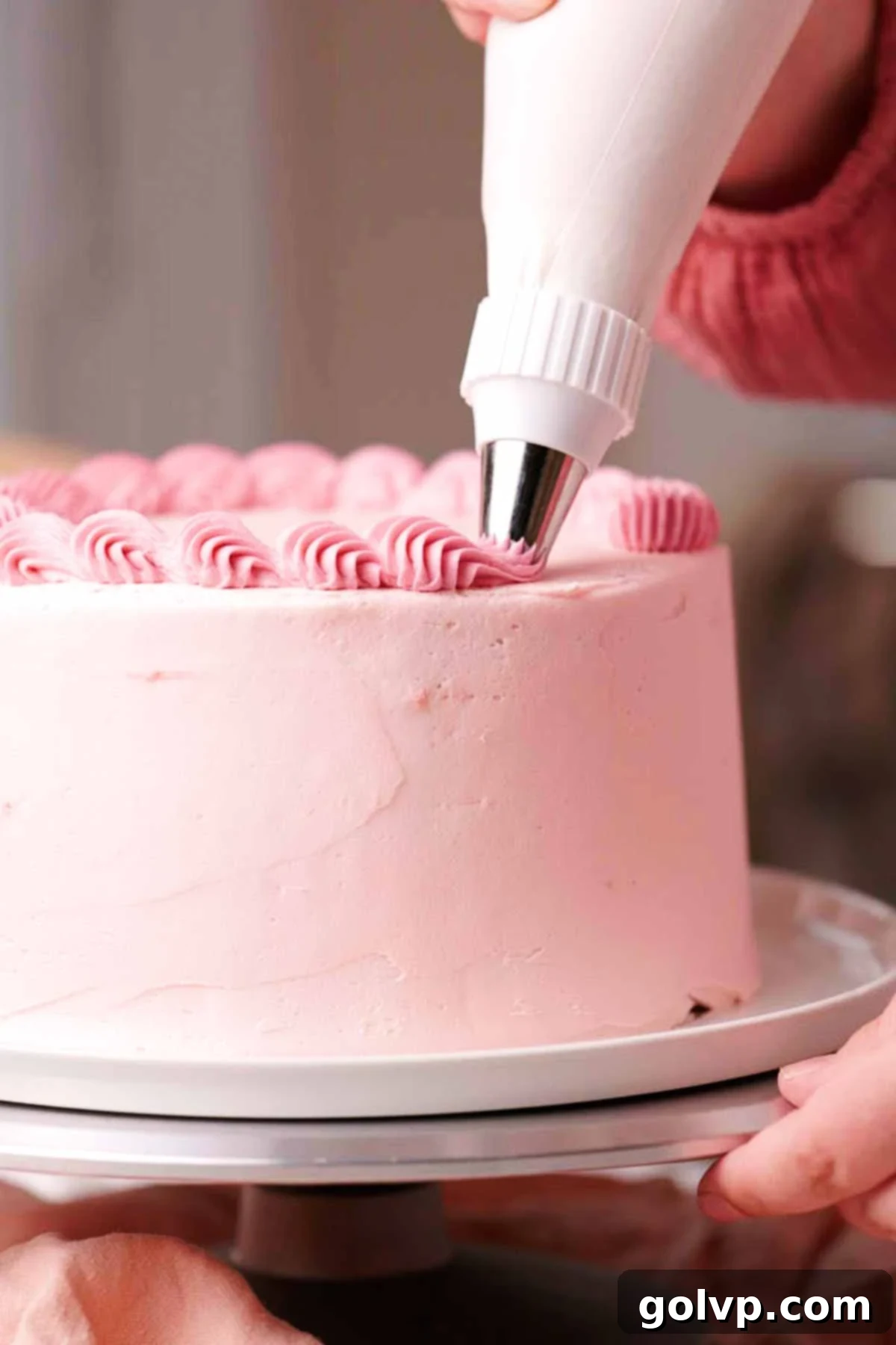 piping top border on frosted pink velvet cake