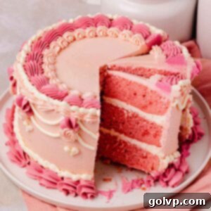 sliced pink velvet cake with pink frosting and vintage piping