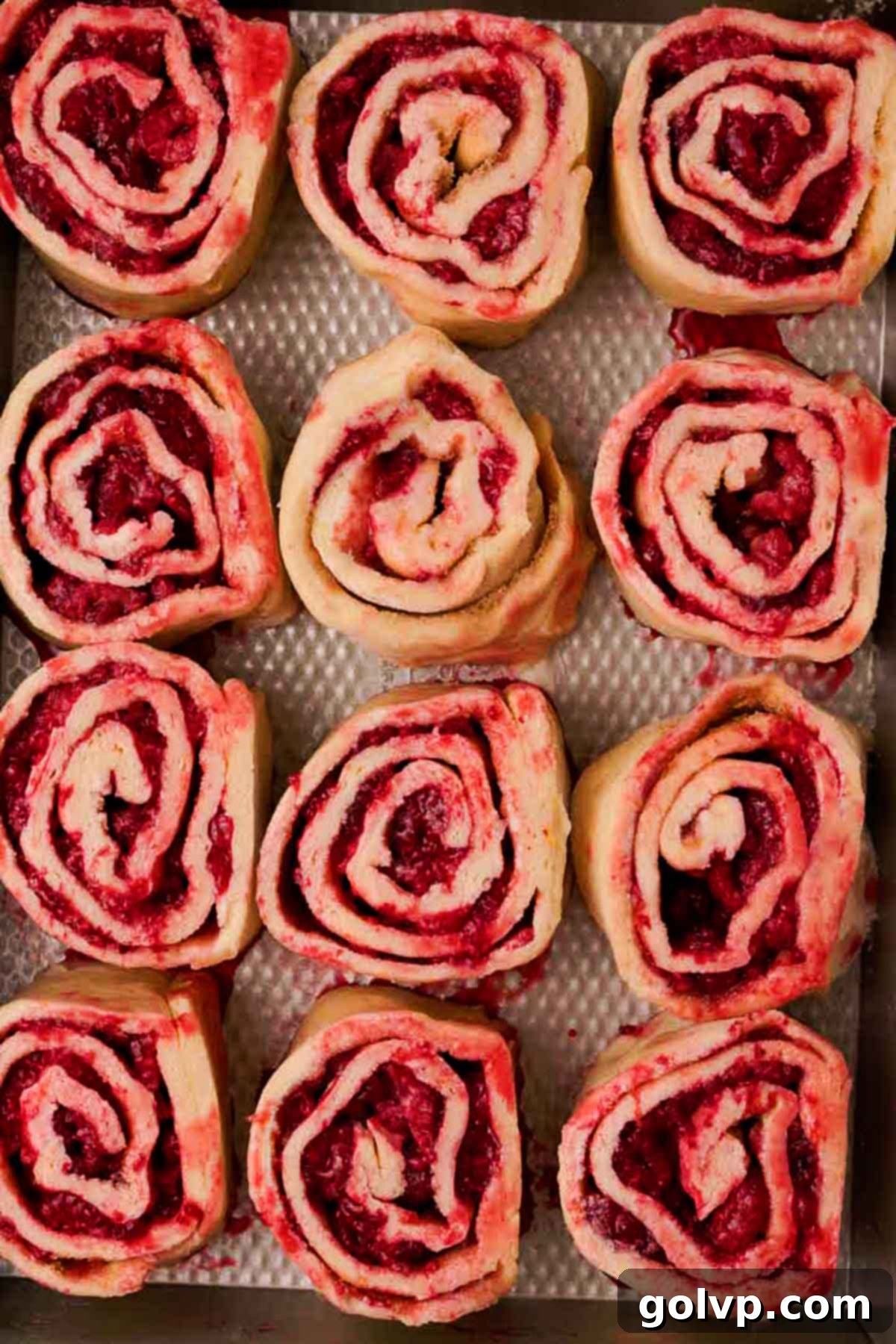 rolled raspberry cinnamon rolls in baking pan ready to bake
