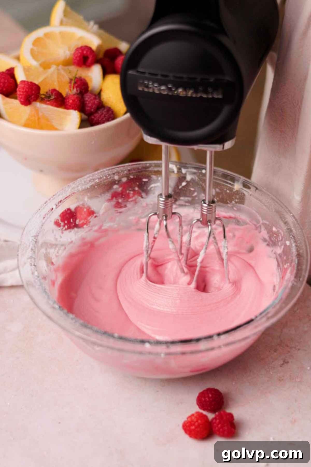 beating cream cheese and raspberry glaze with electric mixer