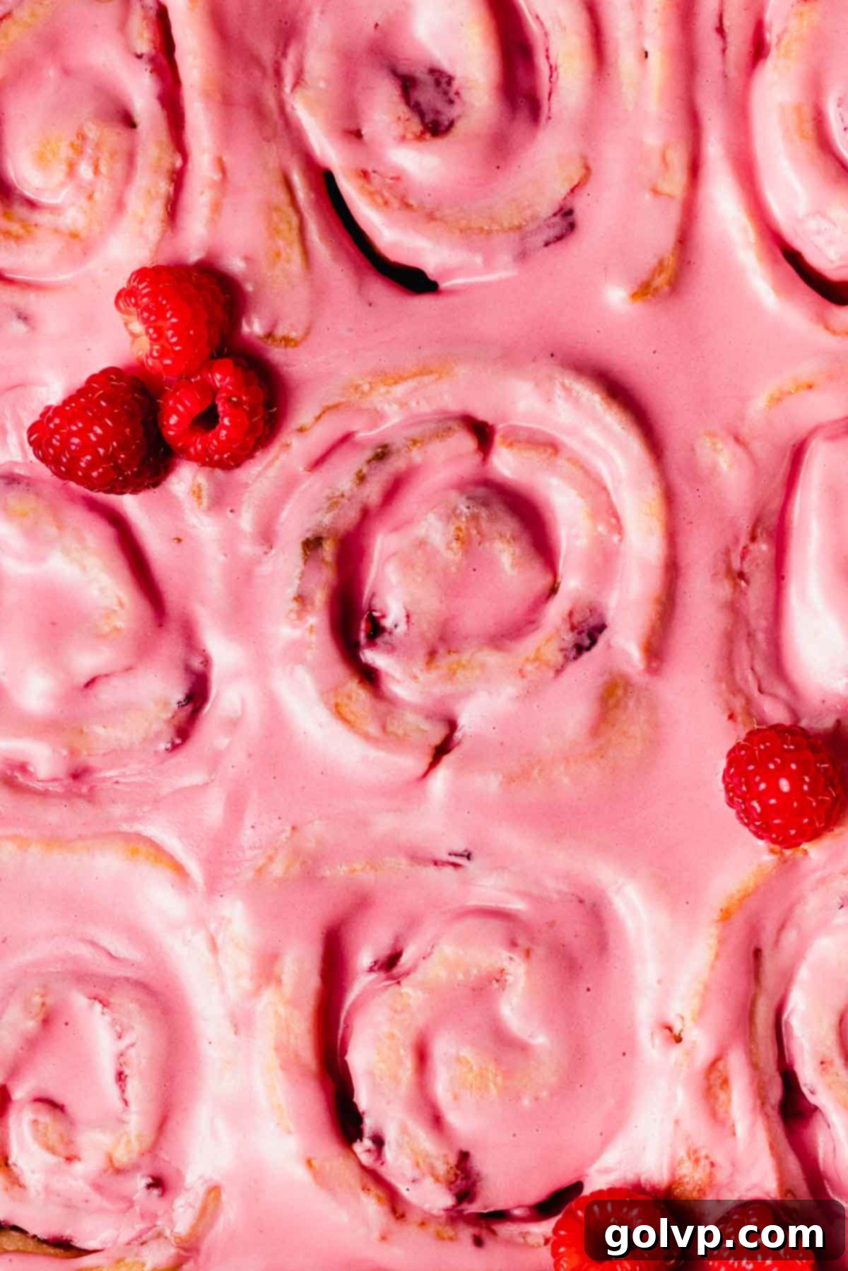 closeup of the top of pink glazed raspberry rolls