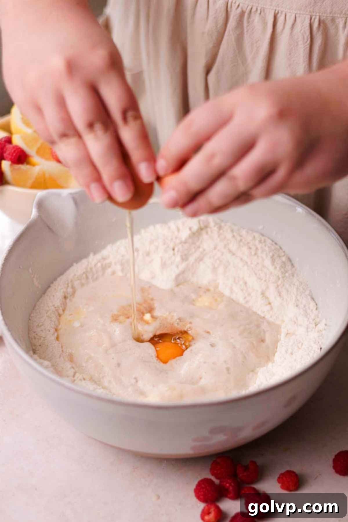 cracking an egg into a bowl filled with flour