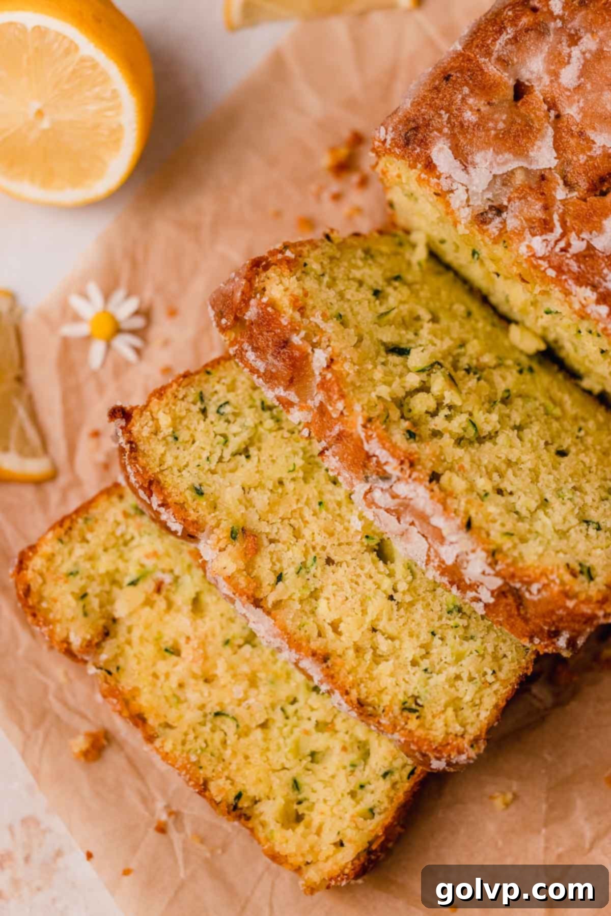Sliced lemon zucchini bread resting on parchment baking paper, showing its perfectly moist interior and the delightful golden crust.